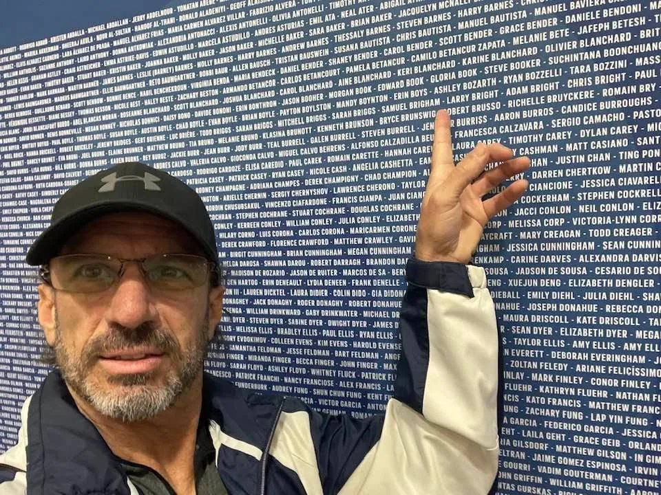 Larry pointing to his name on the wall of Boston Marathon entrants