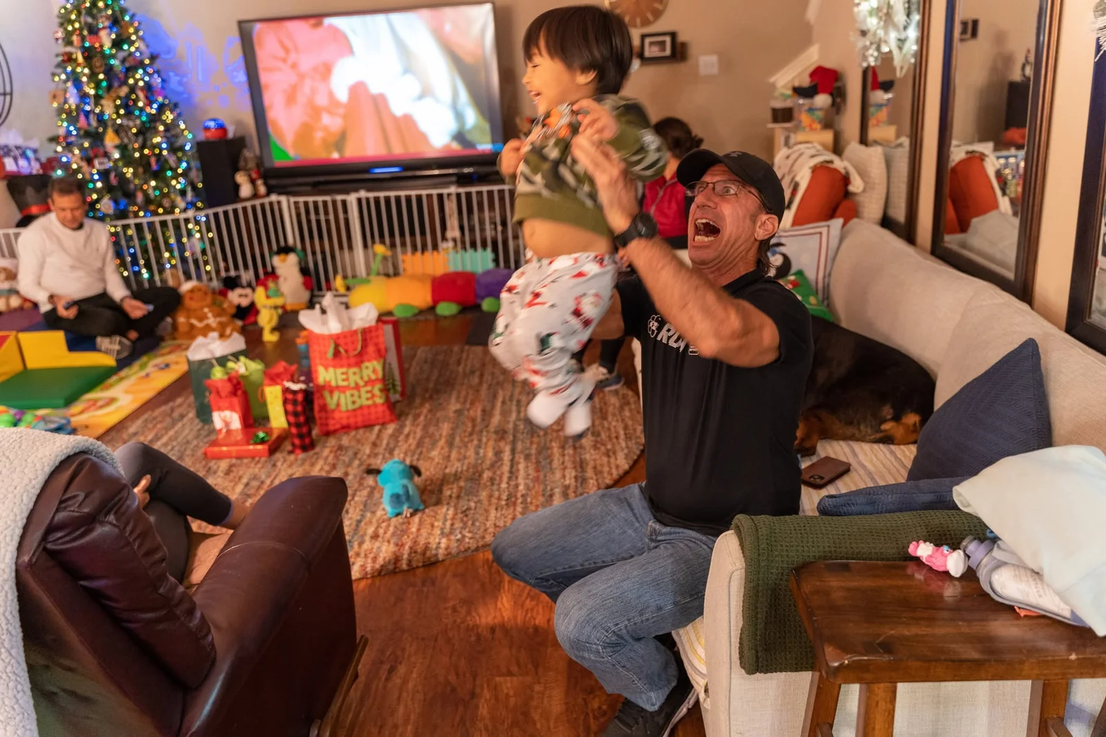 Larry lifting a laughing child during a family gathering