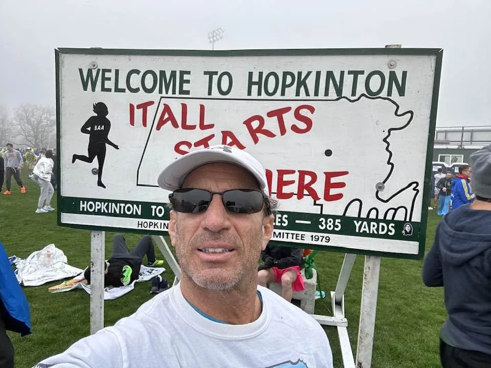 Larry taking a selfie at the Welcome to Hopkinton sign at the Boston Marathon start
