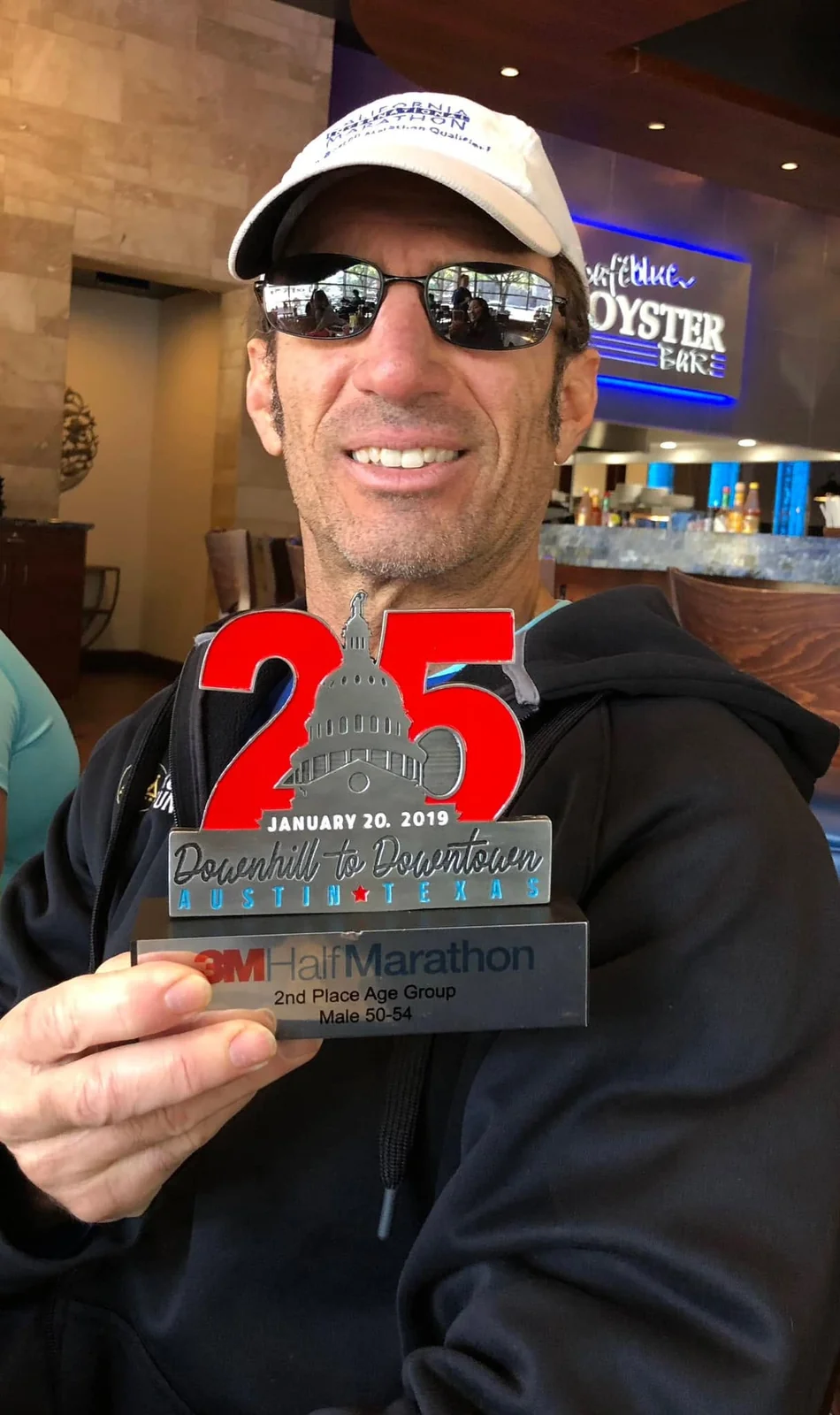 Larry smiling and holding a finisher medal